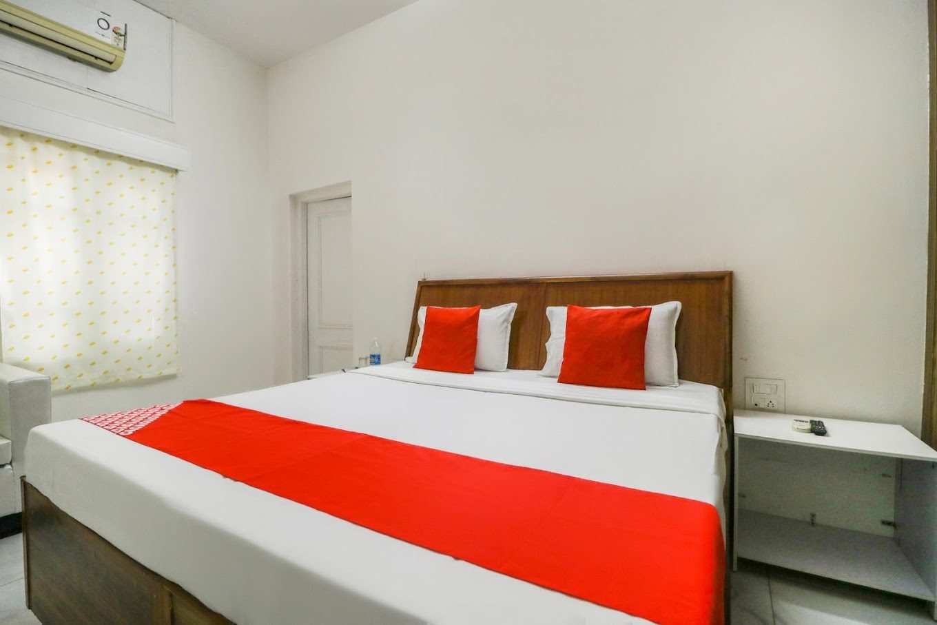 Guest room with wooden headboard and bedside table